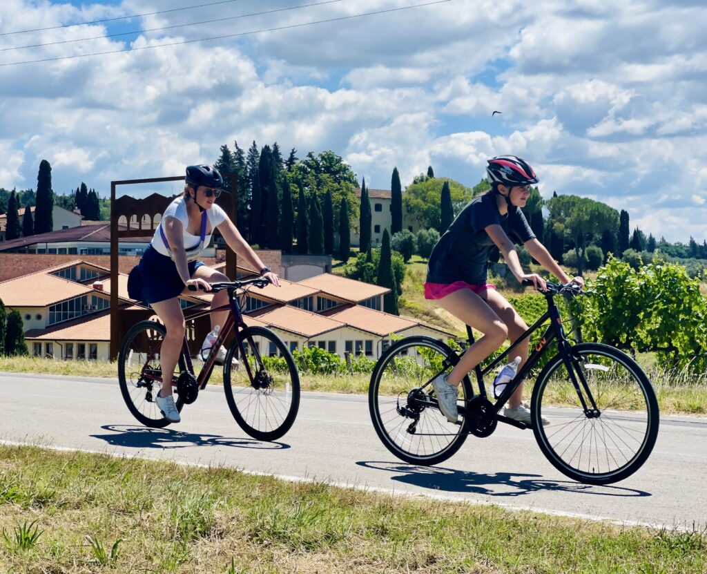A family clcling past vineyards in Chianti  