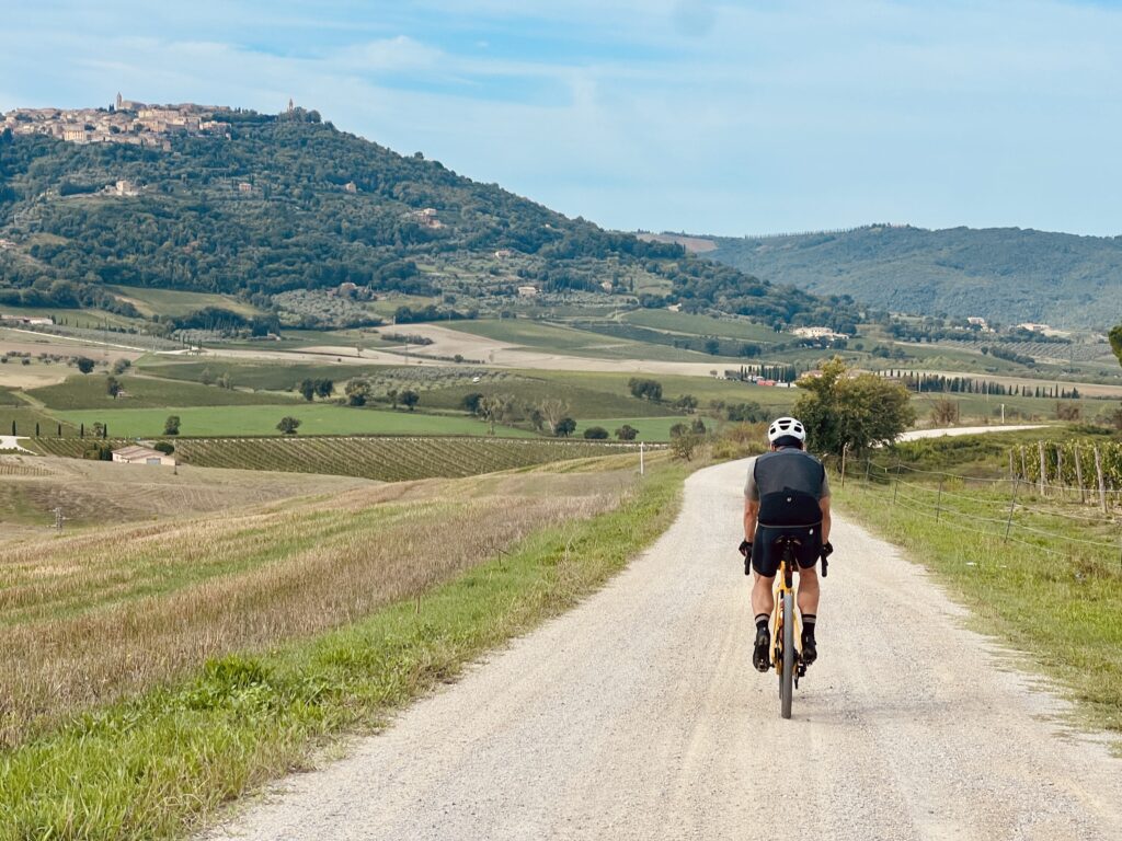 A cyclists rides along the classic strade bianche gravel roads on a two day bike tour in tuscany